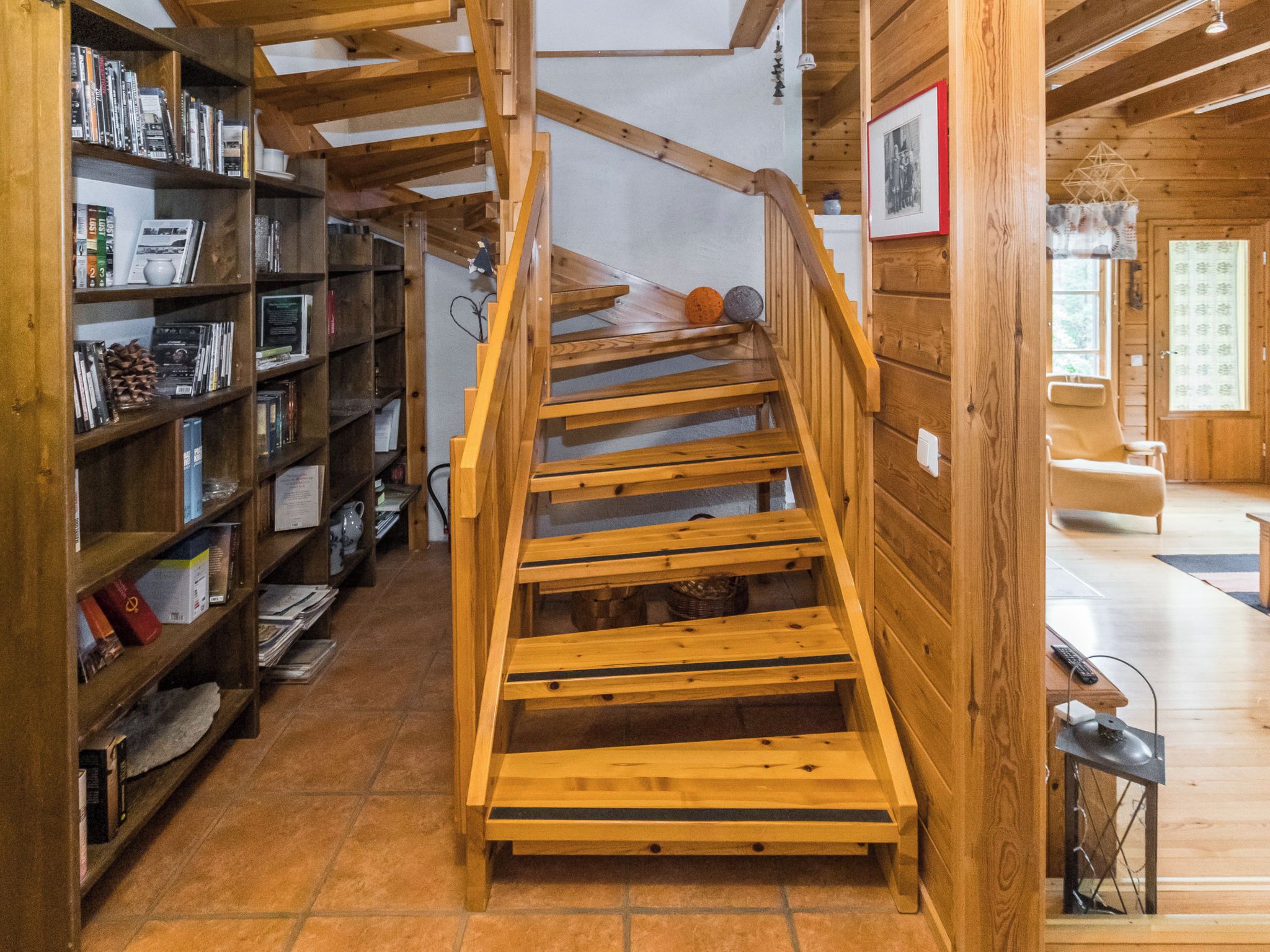 A wooden staircase in a room with bookshelves on either side.