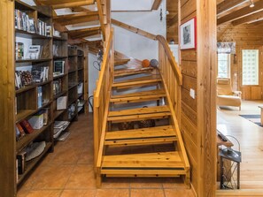 A wooden staircase in a room with bookshelves on either side. - Mustikka by Interhome (Kuusamo)