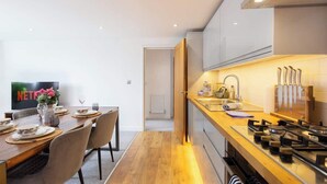 Eine moderne Küche mit einer Holzausziehtafel, einem Gasherd und einem Spülbecken.