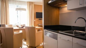 A modern kitchen with a dishwasher, a sink, and a built-in oven. There is a dining area with a table and chairs. - #11 mit Balkon by Interhome (Turracher Höhe)