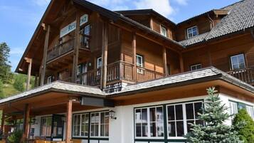 Ein Holzgebäude mit Balkon, überdachter Eingang und einem Schild mit der Aufschrift 'RESIDENCE'.