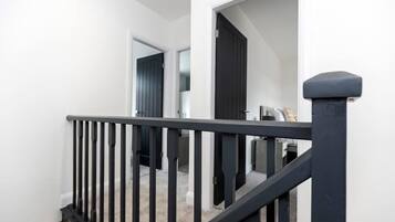 A staircase with black railings leading to a landing.