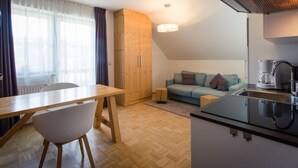 Ein gemütlicher Wohnbereich mit Küchenzeile, Essplatz und Sofa.