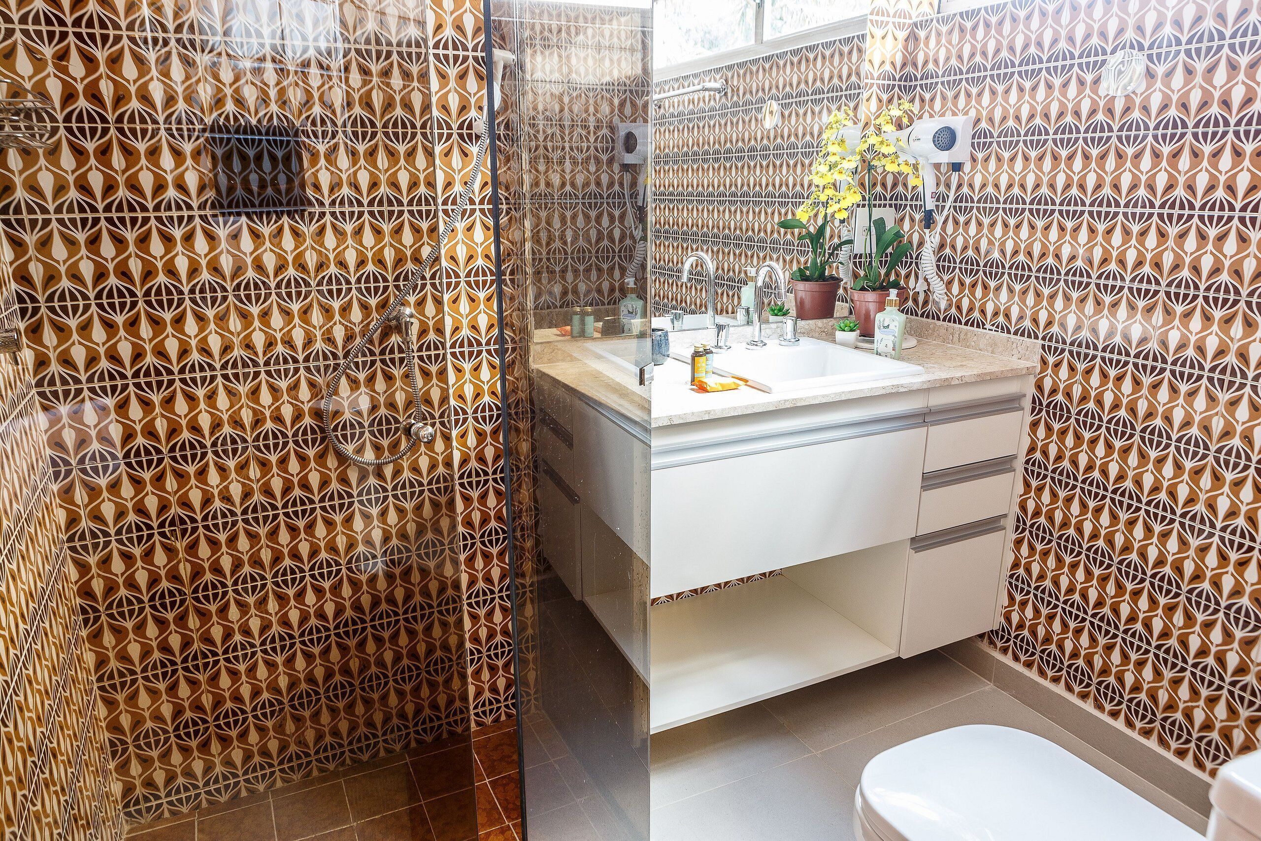 Une salle de bain avec des murs à motifs, un lavabo et des toilettes.