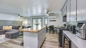 A modern kitchen with a central island, built-in appliances, and a dining area with a table and chairs. - Family-Friendly Broken Bow Home w/ Grill! (Broken Bow)