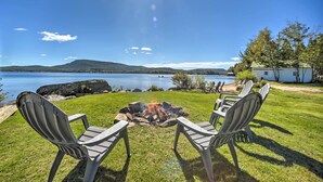 A lakeside view with a fire pit and Adirondack chairs. - Beach & Kayaks: Waterfront Cabin on Lake Pleasant! (Speculator)