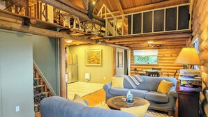 A log cabin interior with a living room, a staircase, and a dining area. - Classic log cabin with stunning views! (Irwin)