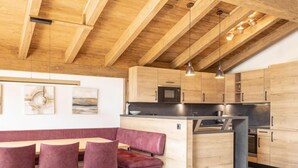 Una cocina moderna con armarios de madera, una isla integrada e iluminación colgante.