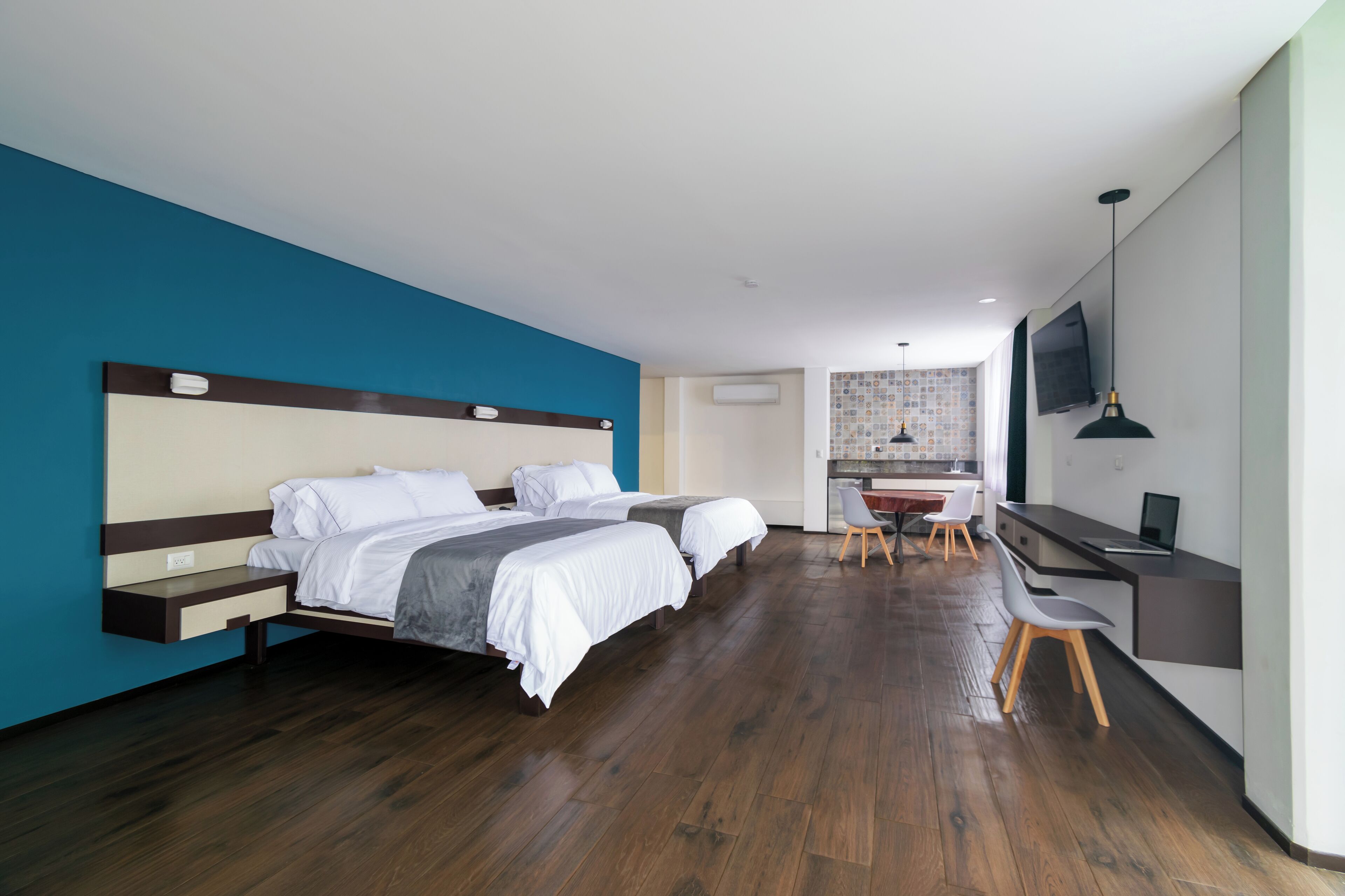 Una habitación de hotel moderna con una cama grande, un escritorio y un televisor.