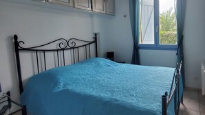 A bedroom with a bed, a window with curtains, and a ceiling light. - Centrally located apartment with swimming pool (Fréjus)