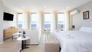 A modern hotel room with a large bed, a seating area with a table, and a TV. - Home2Book Stylish Sea Views Studio Santa Cruz (Santa Cruz de Tenerife)