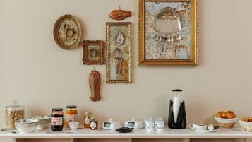 A breakfast buffet setup with various food items, utensils, and decorative items on a table.