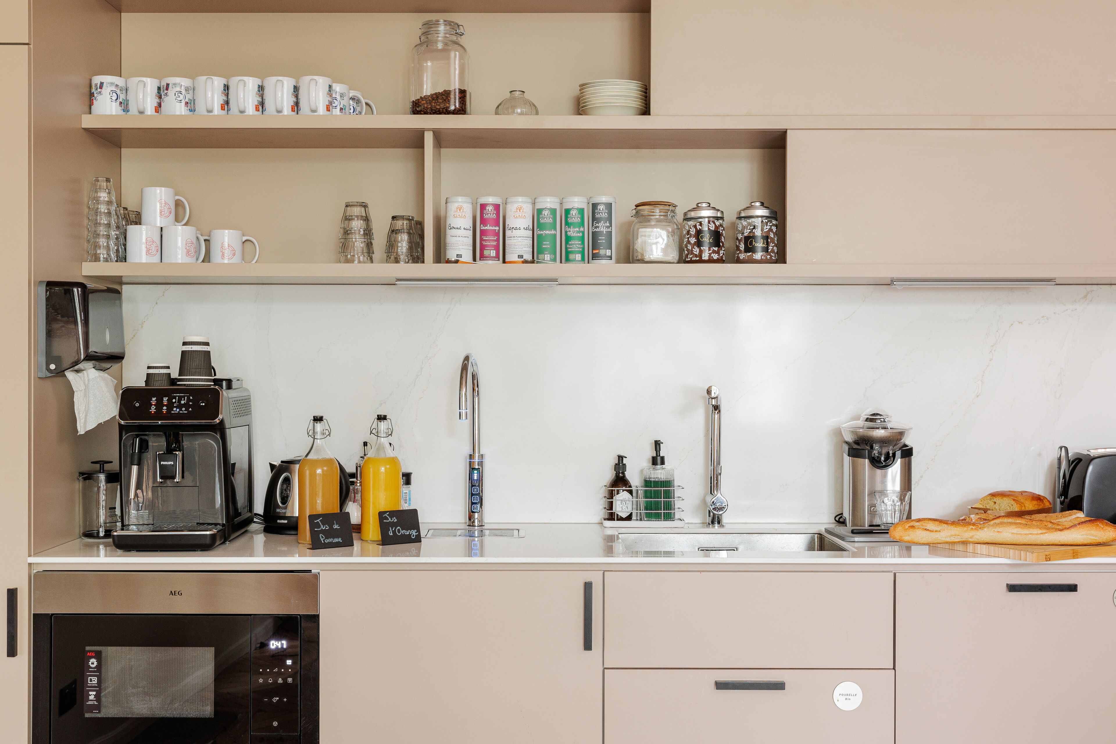 Una cocina moderna con cafetera, máquina de espresso y varios tarros y recipientes de almacenamiento.