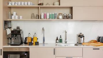 A modern kitchen with a coffee machine, espresso machine, and a variety of storage jars and containers.