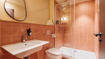 A bathroom with a sink, toilet, and shower.