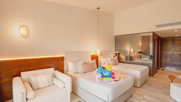 A modern hotel room with a sofa, a chair, a small table, and a bed. There is a mirror on the wall and a window with curtains.