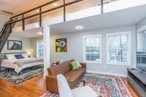 Relax in this inviting living area with a large bed, comfortable sofa, and flat-screen TV.