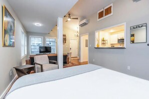 Relax in a spacious room with a large bed, TV, and desk area.