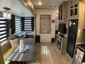 Cozy space with a kitchenette, seating area, and tiled floor.