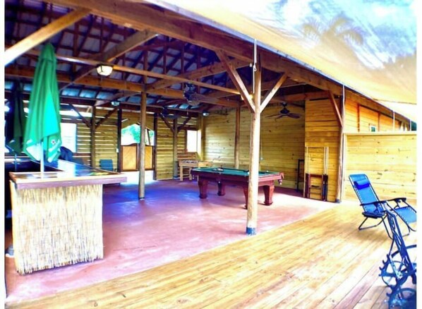 Enjoy a game of pool or billiards in this spacious indoor recreation area with a bar and comfortable seating.