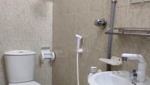 Une salle de bain avec des toilettes, un lavabo et une douche.