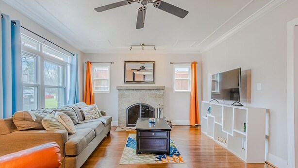 A living room with a fireplace, a sofa, a coffee table, and a TV on a stand. - Cozy Craftsman in the Center of Oak Cliff (Dallas)