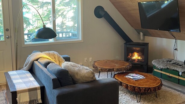 Una sala de estar acogedora con un sofá, una mesa de centro y una chimenea.