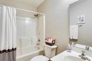 Un bagno con vasca, WC, lavandino e specchio.