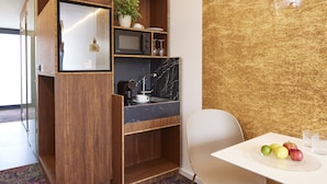 A compact kitchen with a built-in microwave, a sink, and a small dining area with a table and chairs. - TIN INN Montabaur (Montabaur)