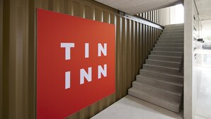 A staircase with a large red sign reading "TIN INN" on the wall. - TIN INN Montabaur (Montabaur)