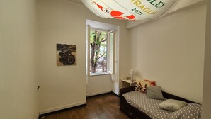 Une chambre à coucher avec un lit, une fenêtre, une porte et un tableau accroché au mur.