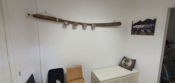 A room with a curved wooden structure hanging from the ceiling, a small table with a cushion, and a framed picture on the wall. - Apartment in the center of Genoa, close to all amenities and public transportation (Genova)