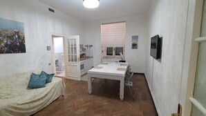 Une chambre avec un lit, une table et un téléviseur.