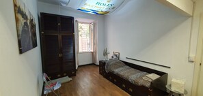 Ein Schlafzimmer mit Bett, Fenster, Deckenventilator und Tür.
