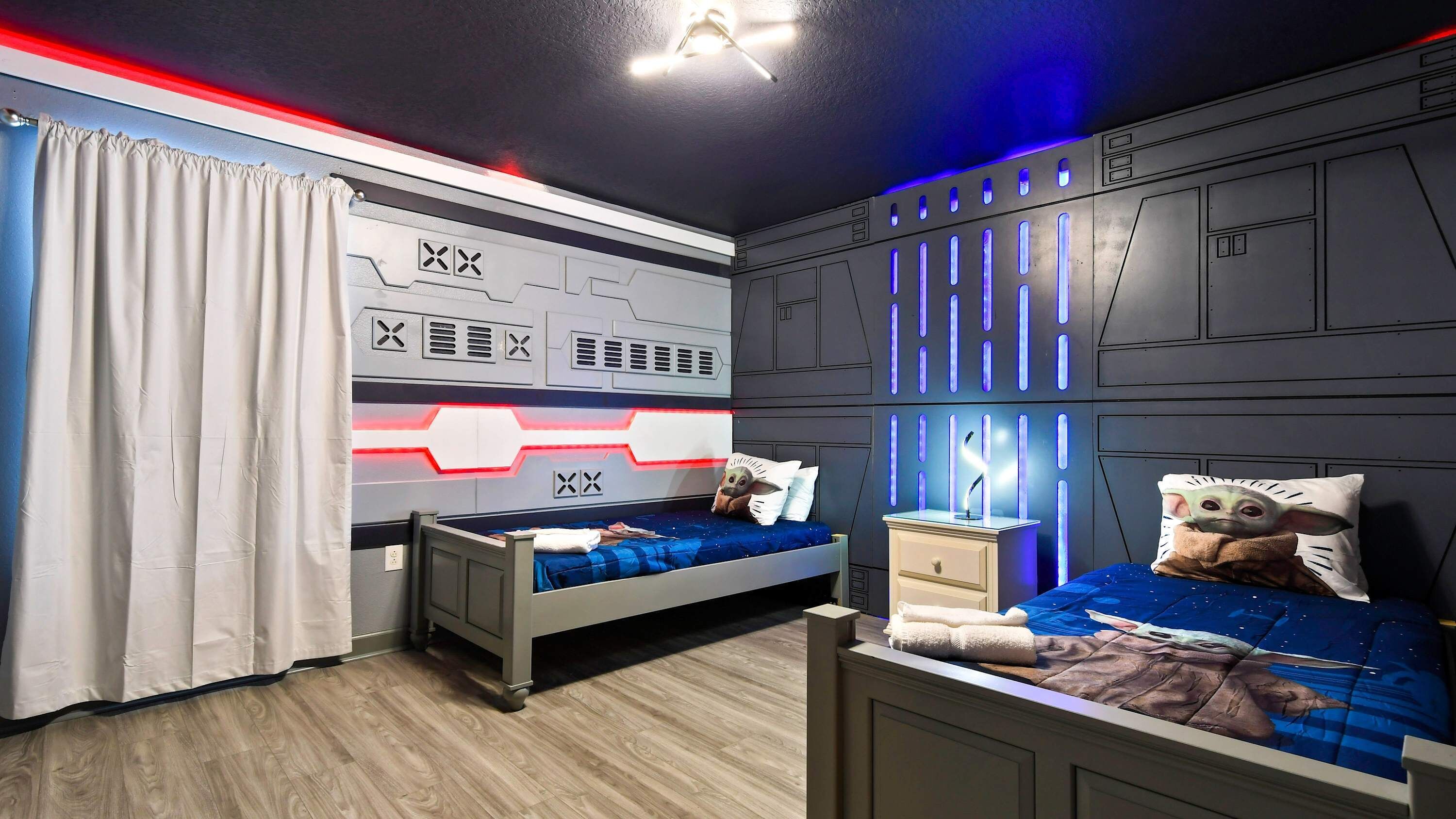 A bedroom with a bed, a nightstand, and a wall panel with a geometric design.