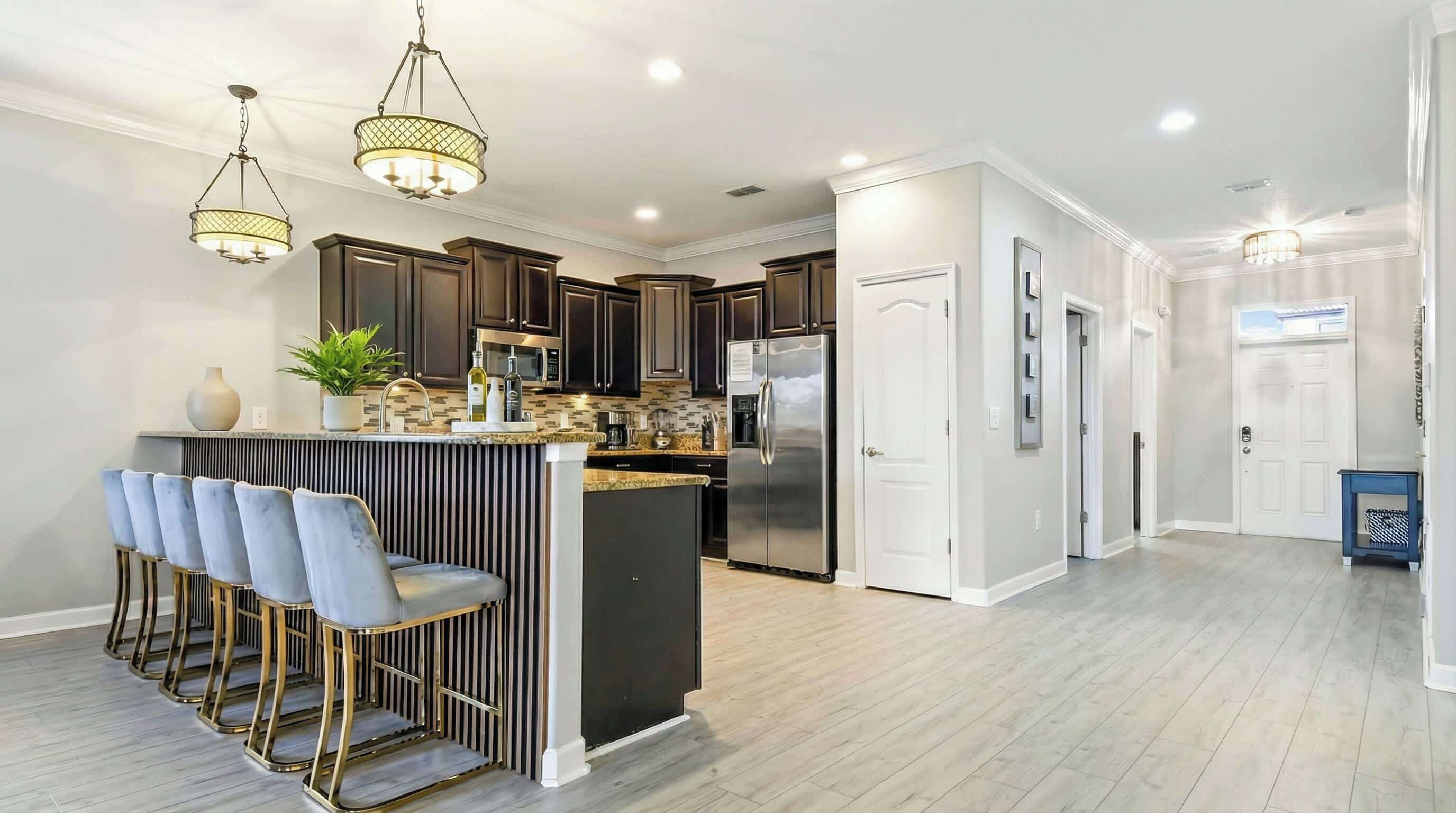 A modern kitchen with dark wood cabinets, stainless steel appliances, and a central island with bar stools.