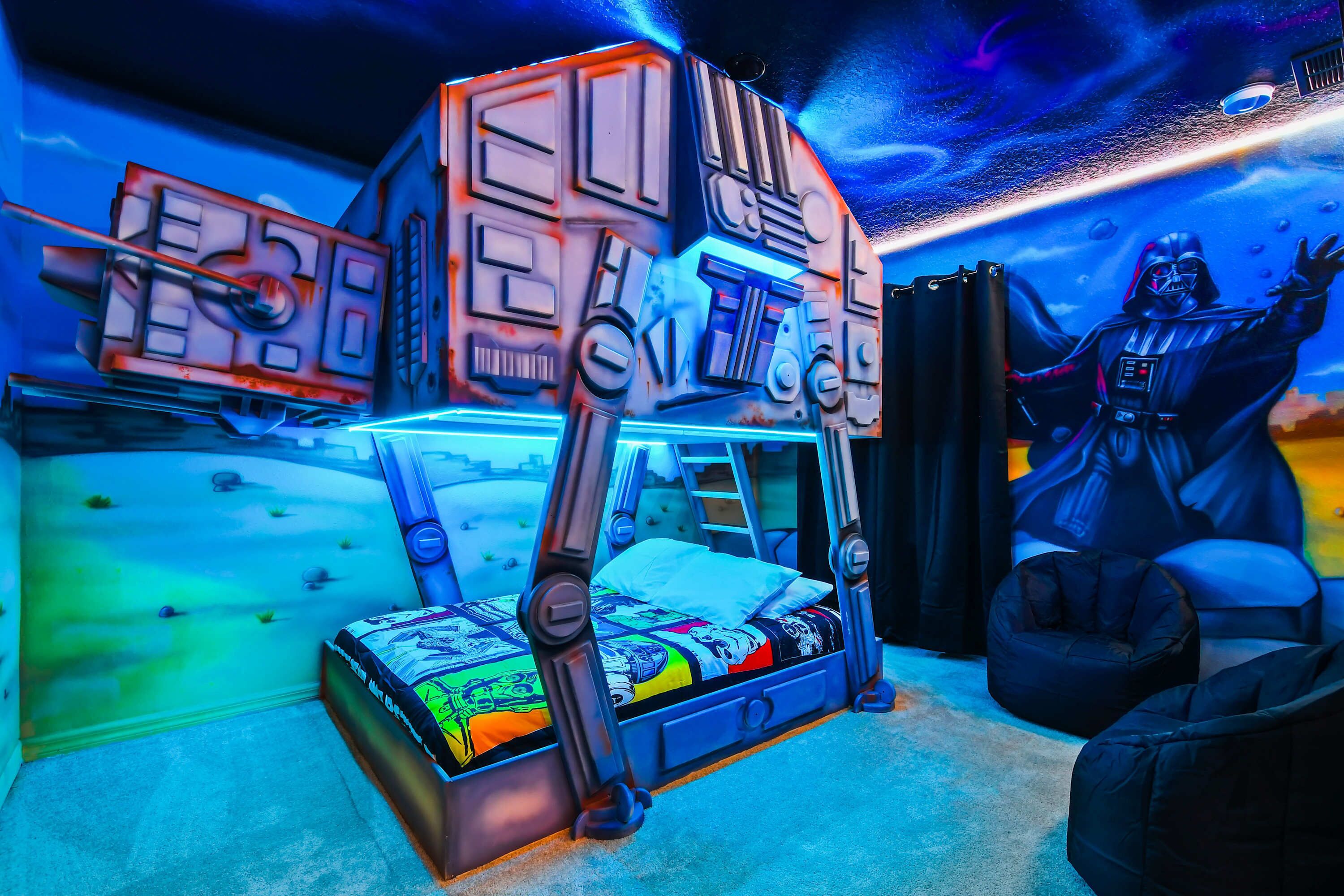 Une chambre avec un lit, une fresque murale sur le thème de Star Wars et une statue de Dark Vador.