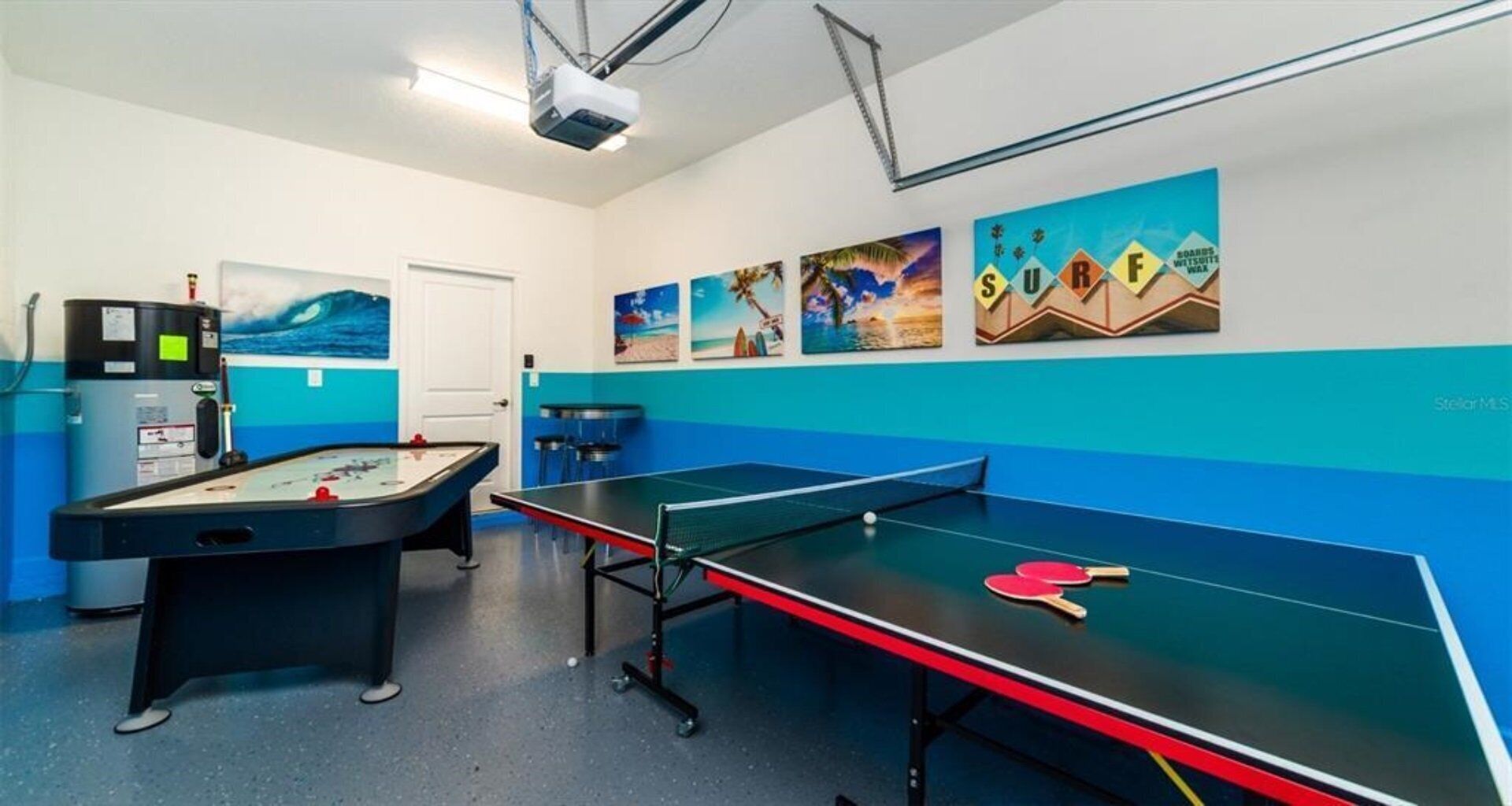 Ein Raum mit Kicker, Tischtennisplatte und Projektorleinwand.