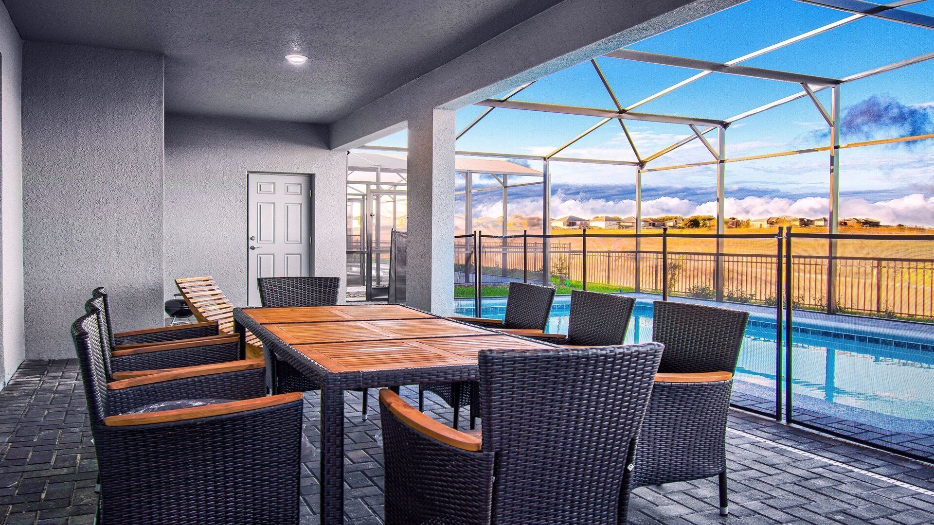 A covered patio area with a pool, outdoor furniture, and a view of the landscape.