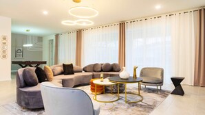 Een moderne woonkamer met een modulaire bank, een ronde salontafel en een grijze fauteuil.
