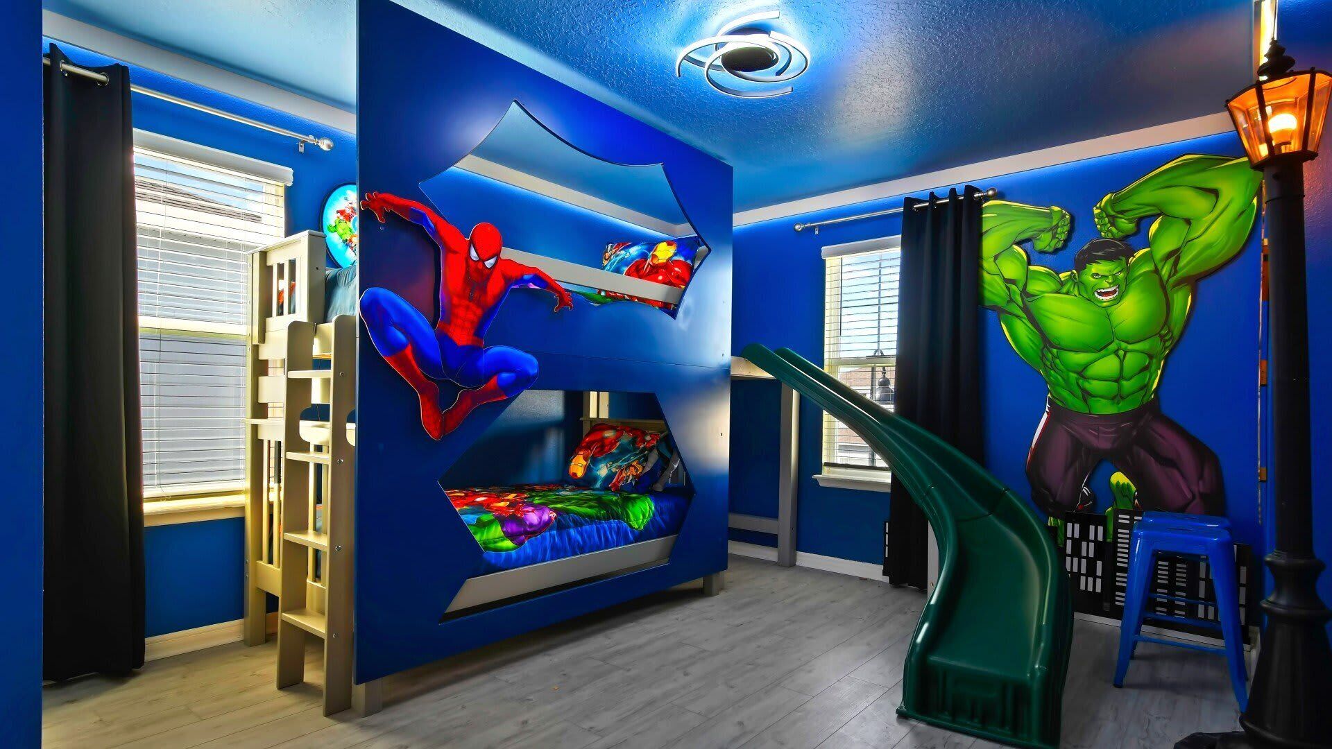 Ein Kinderzimmer mit Etagenbett, Wandbildern zum Thema Superhelden und einer grünen Hulk-Figur.