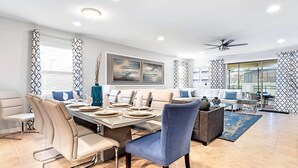 A modern dining area with a large table, chairs, and a ceiling fan. - Special Offer Spacious Home With Pool! (Kissimmee)