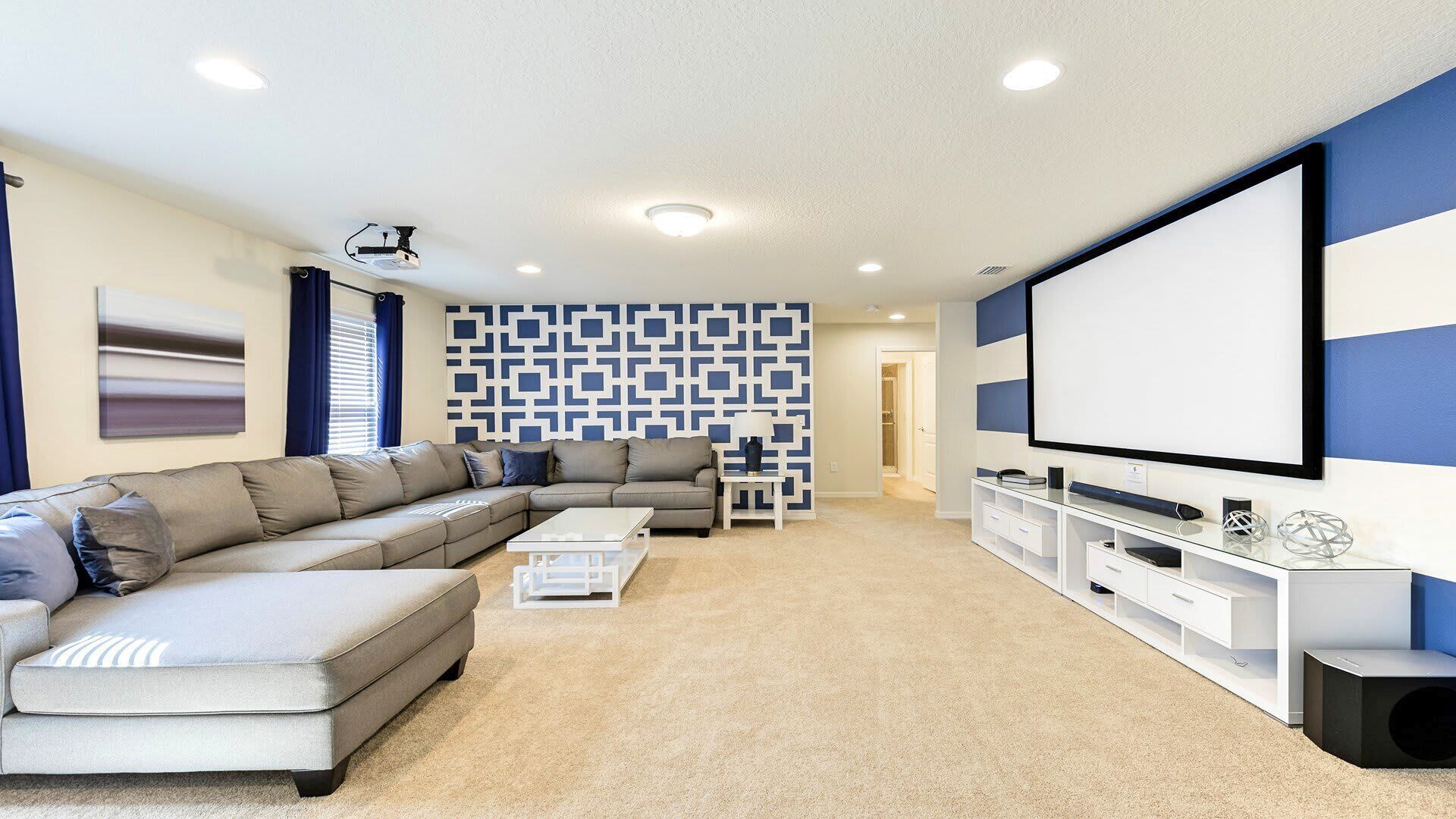 A modern living room with a sectional sofa, a flat-screen TV, and a patterned wall.