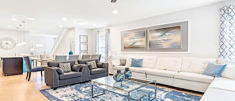 A modern living room with a sofa, coffee table, and artwork on the wall.