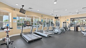 Une salle de sport équipée de tapis de course, de vélos elliptiques et de poids libres.