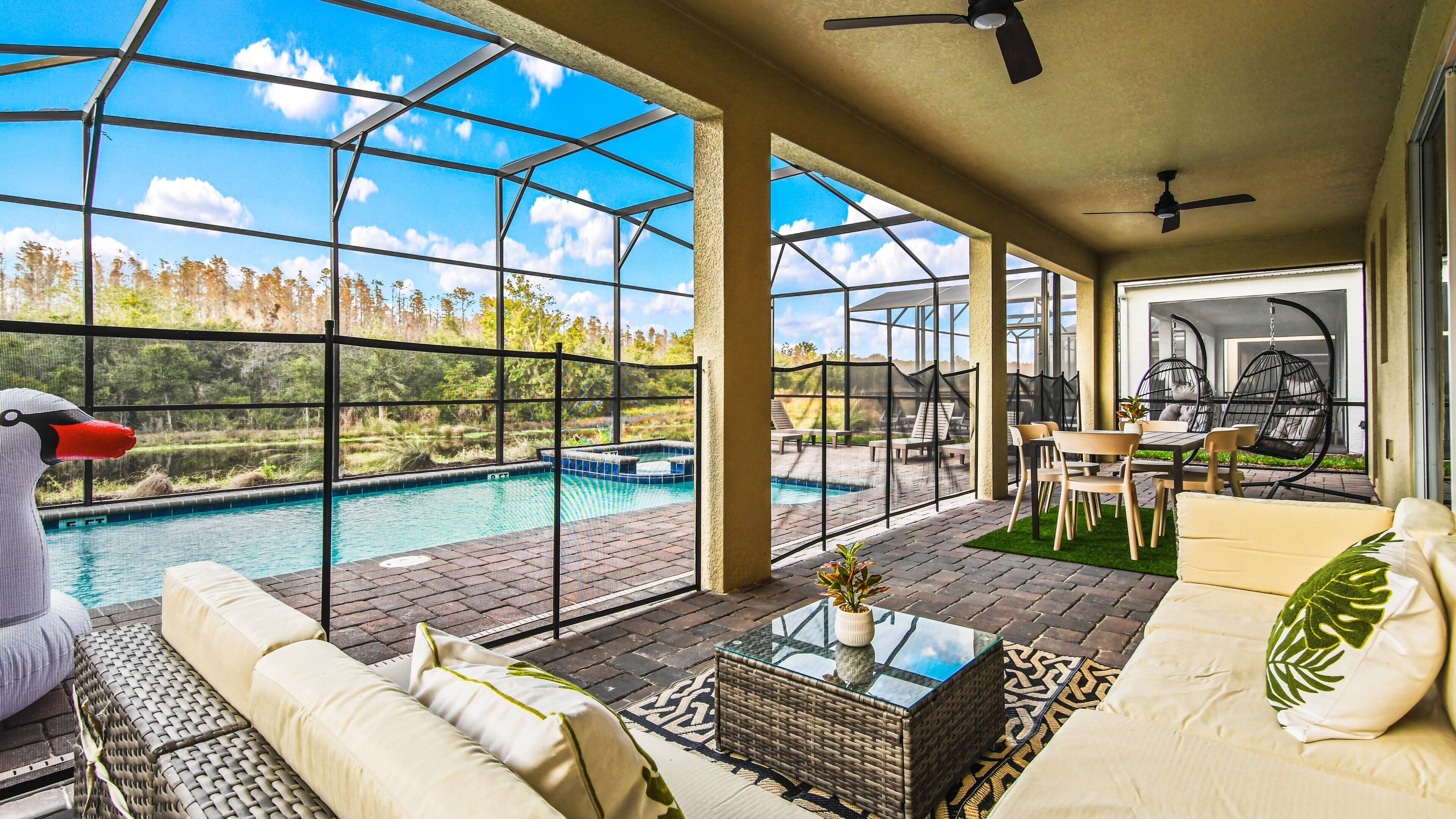 A spacious outdoor area with a pool, seating, and a view of the surrounding landscape.