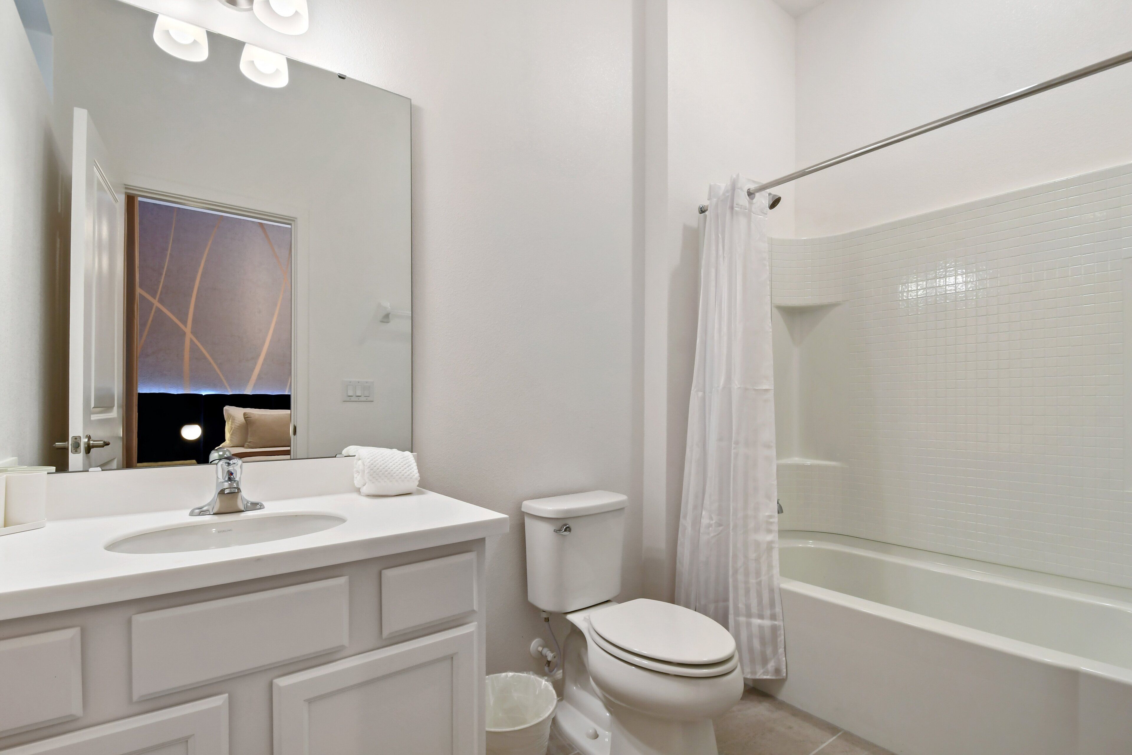 Une salle de bain moderne avec un lavabo, des toilettes et une baignoire, le tout de couleur blanche.
