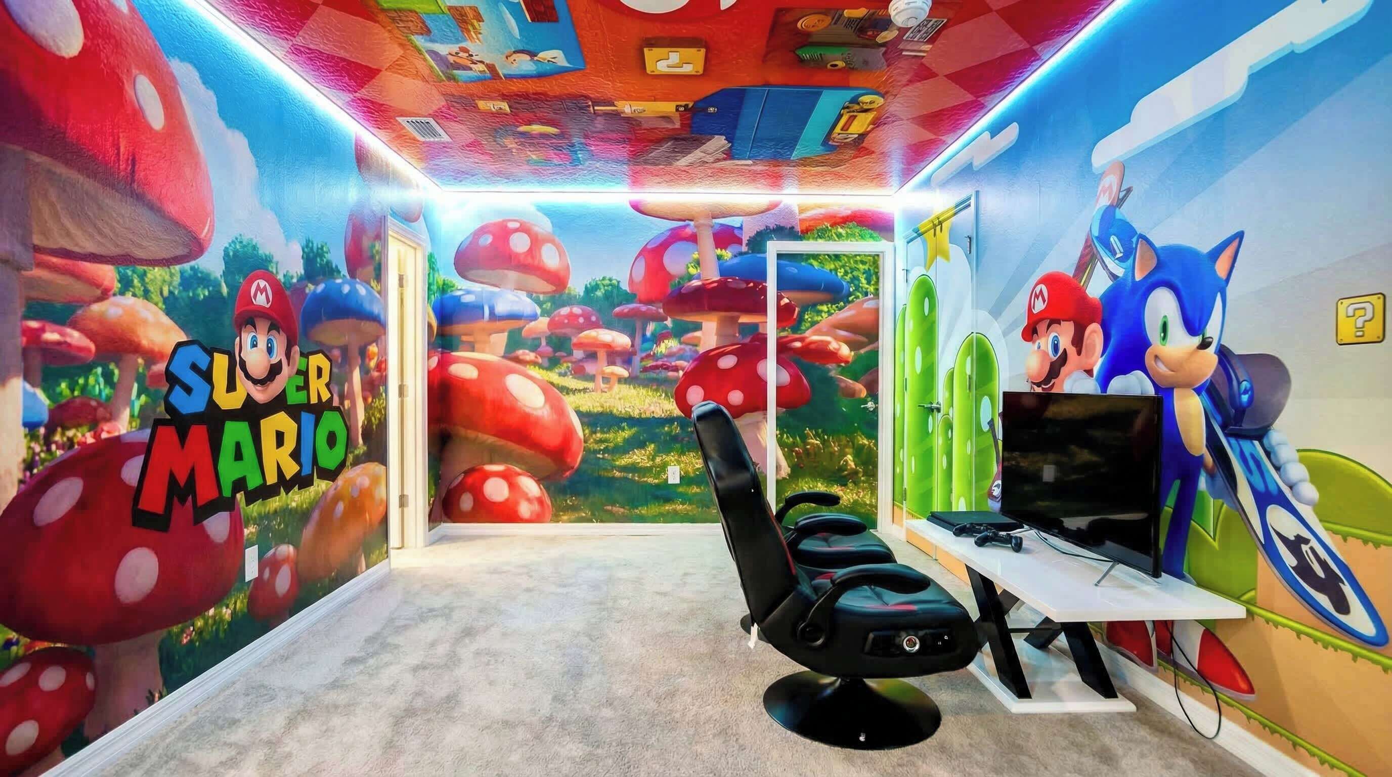 A room with a Mario-themed mural, a gaming chair, a TV, and a Sonic the Hedgehog figure.