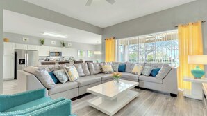 A modern living room with a sectional sofa, a coffee table, and a teal armchair.