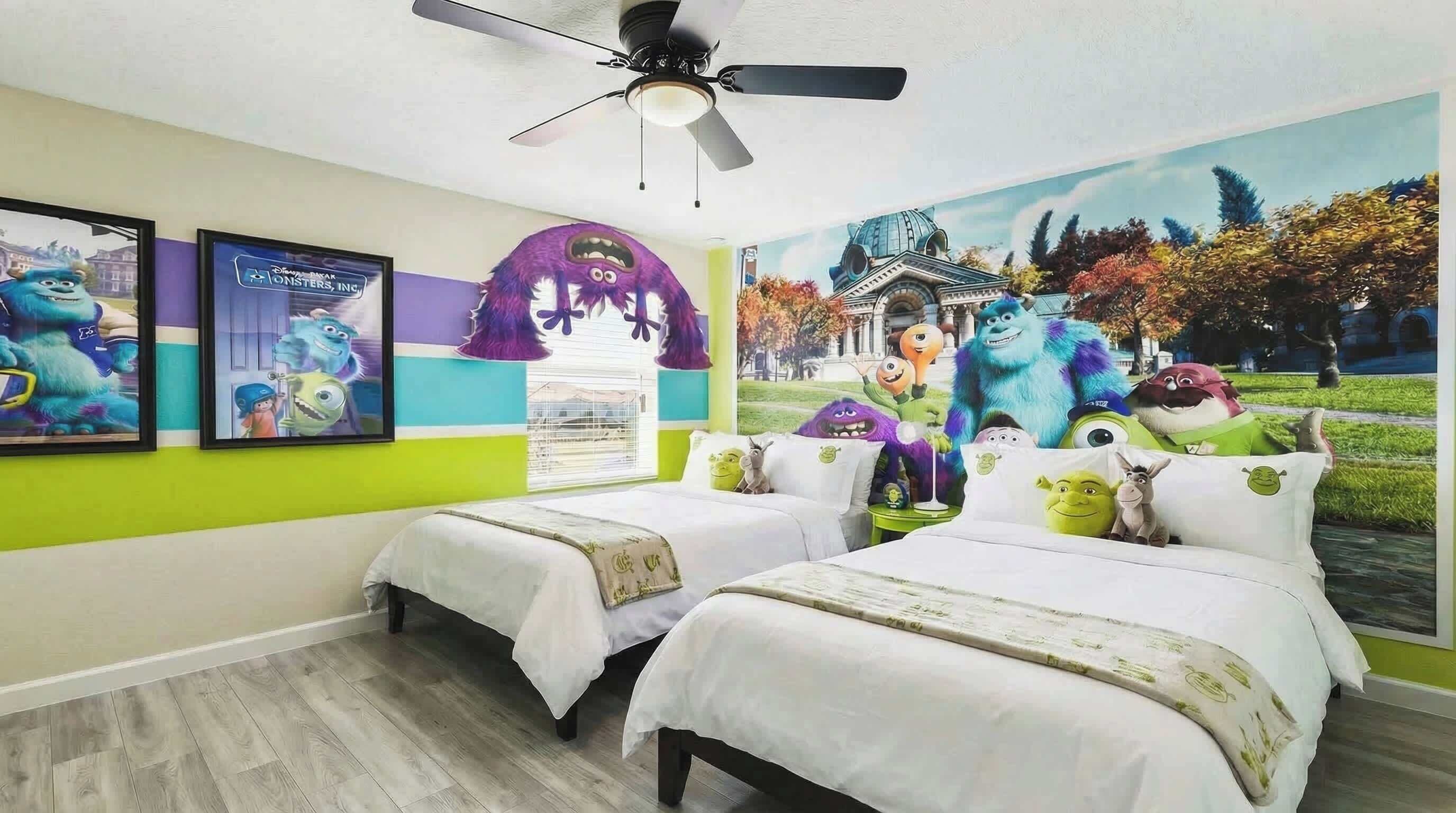 A bedroom with two beds, a ceiling fan, and a mural of animated characters.